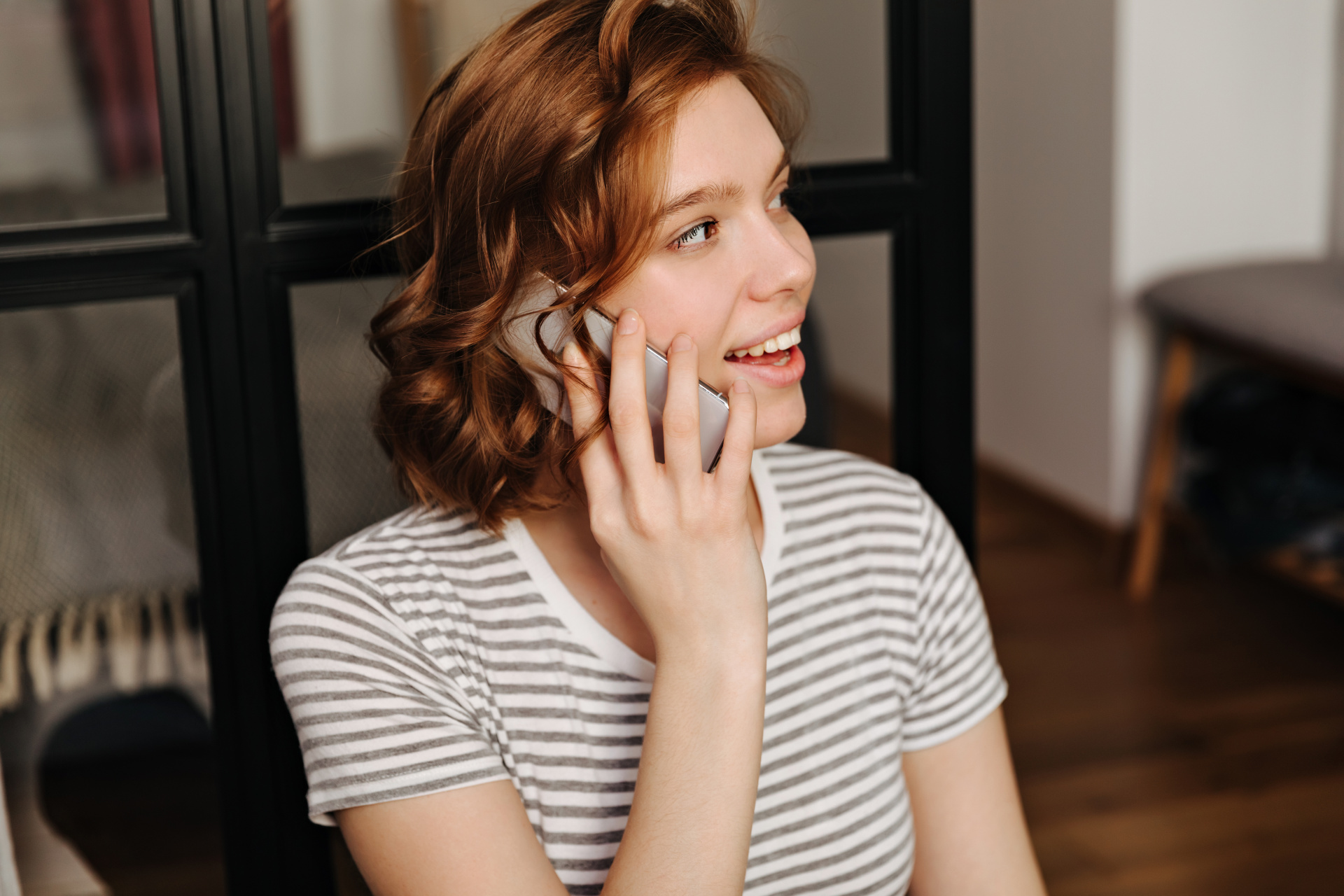 portret-krupnogo-plana-krasnoi-kurcavoi-devuski-v-polosatoi-futbolke-razgovarivaet-po-telefonu.jpg